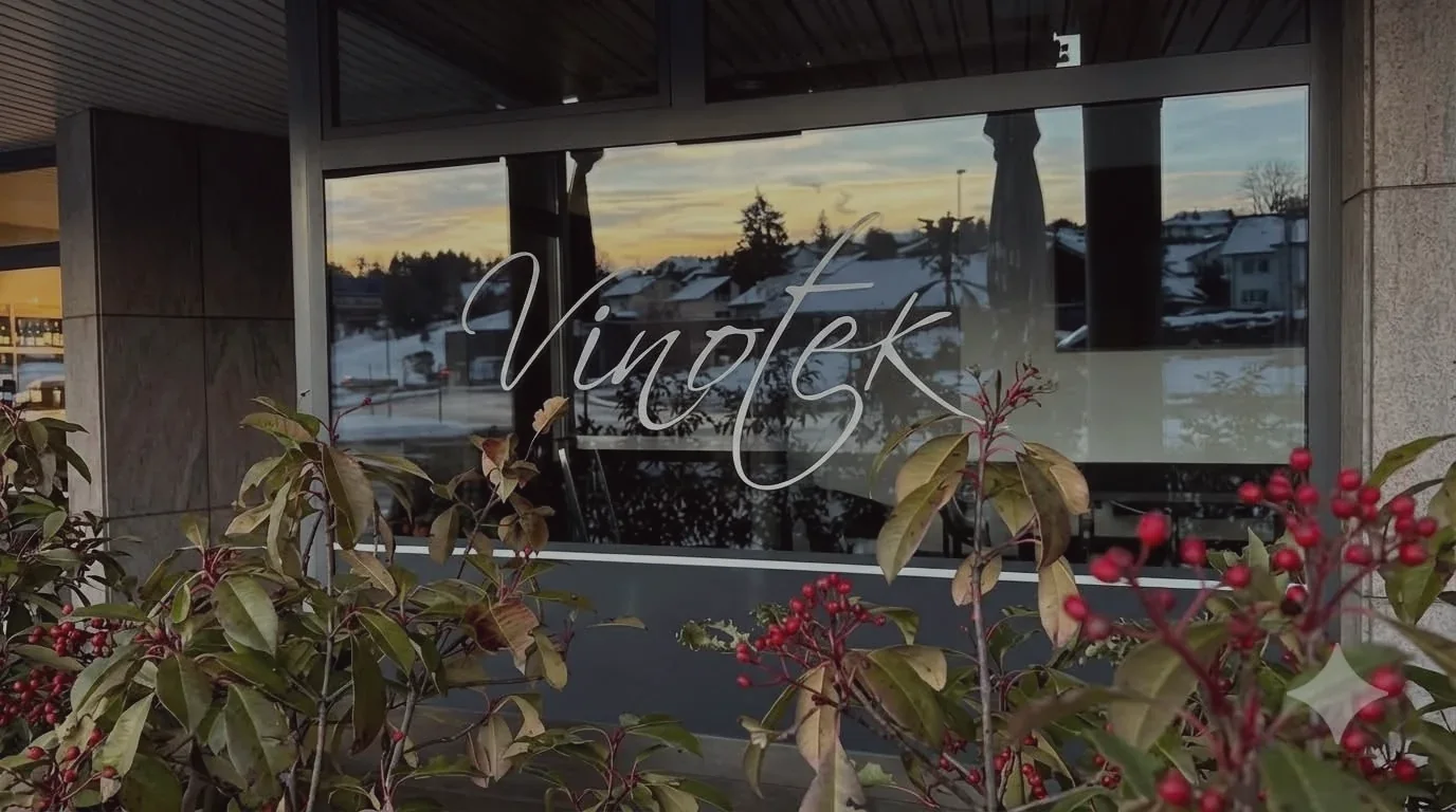 La vitrine de La Vinotek au coucher du soleil, avenue de la Gare, avec l'enseigne Vinotek