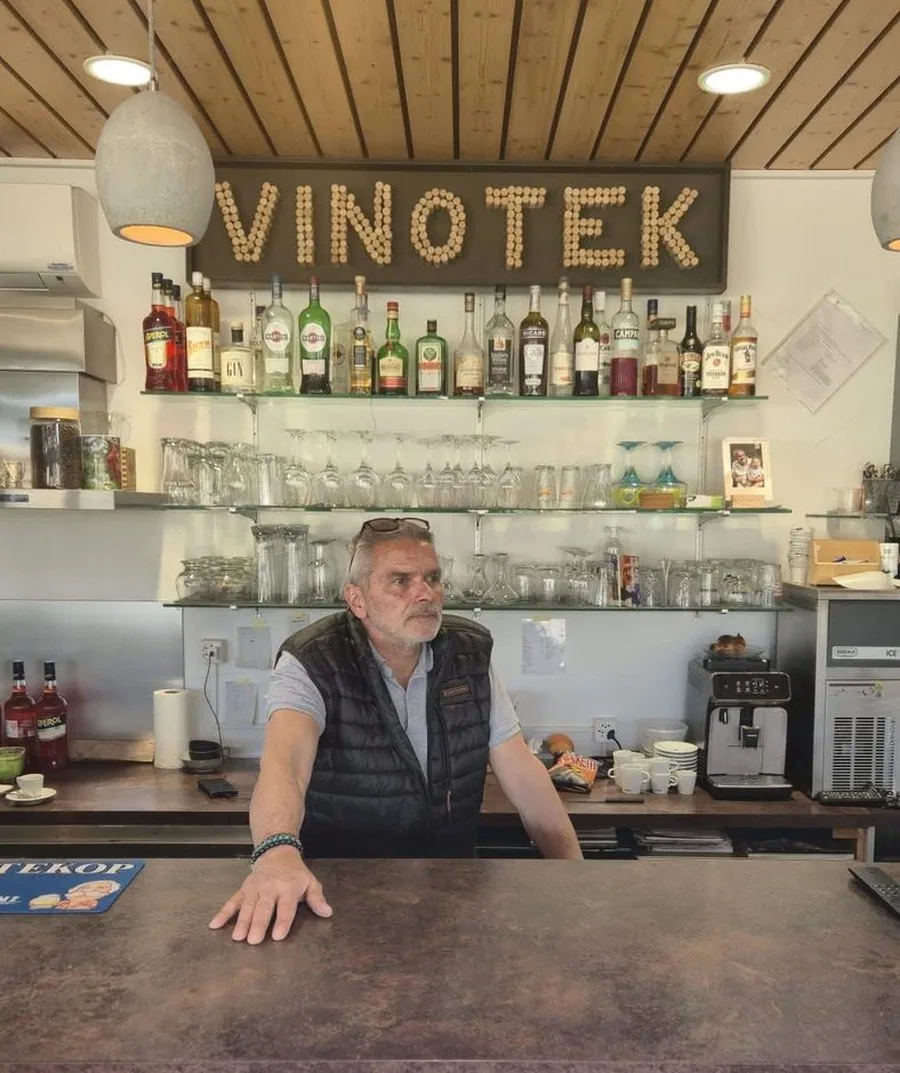 Patrick, le patron de La Vinotek, derrière son comptoir sous l'enseigne en bouchons de liège