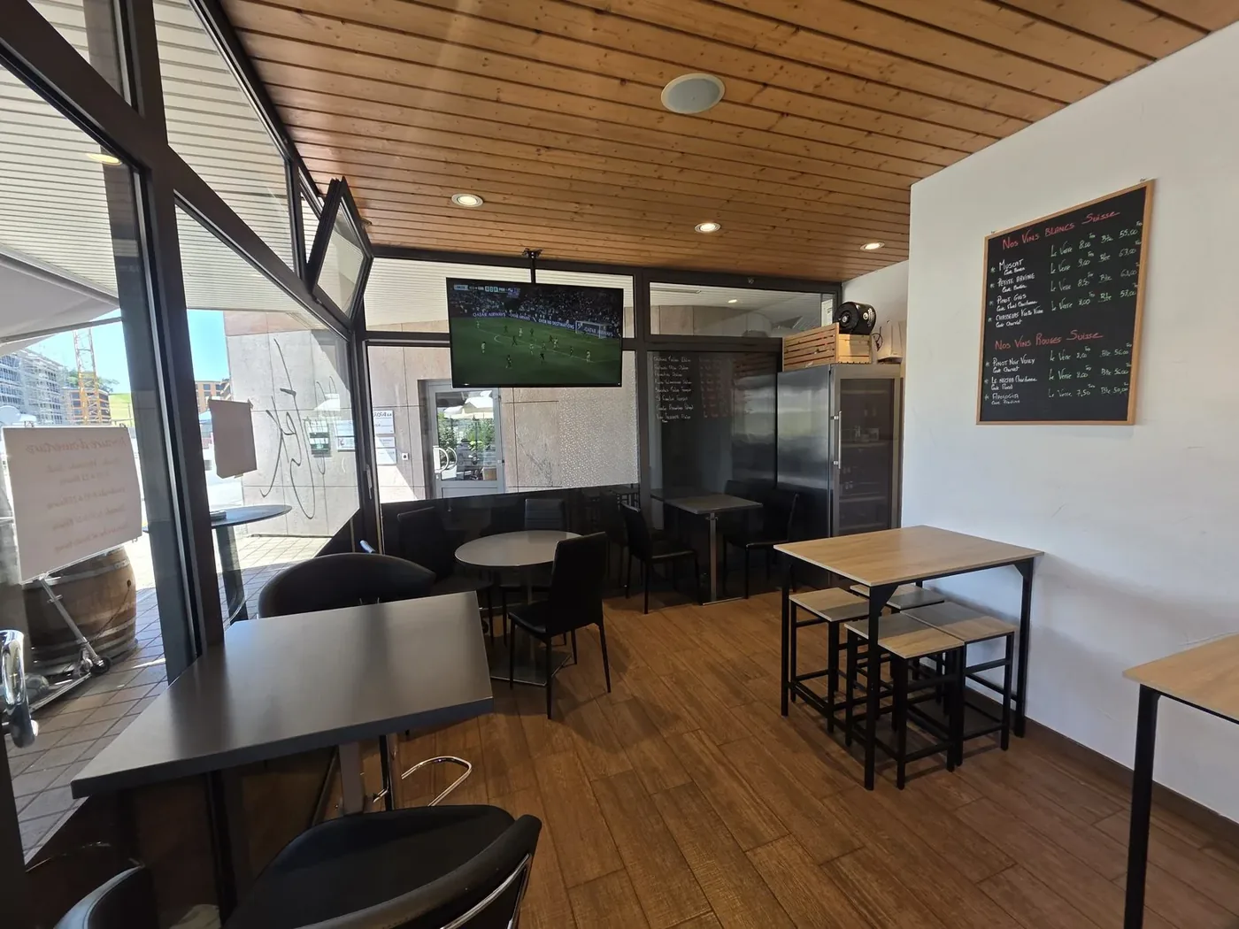 La salle de La Vinotek avec ses tables hautes